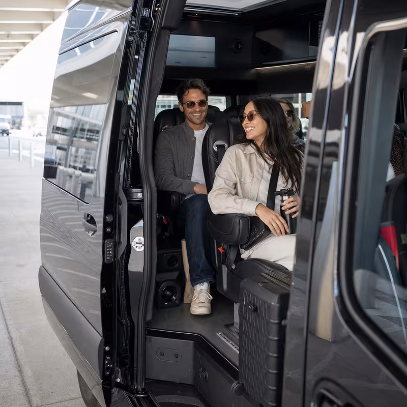 Passengers loading luggage while boarding an Lincoln group shuttle