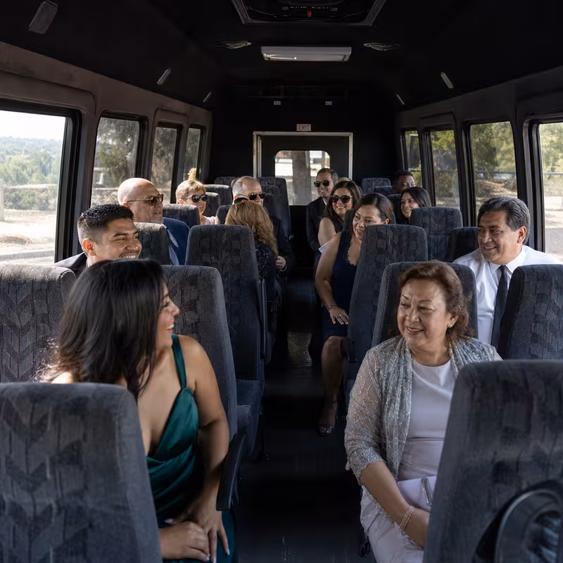 Group boarding a white charter bus for Private Event Transportation transportation in Lincoln