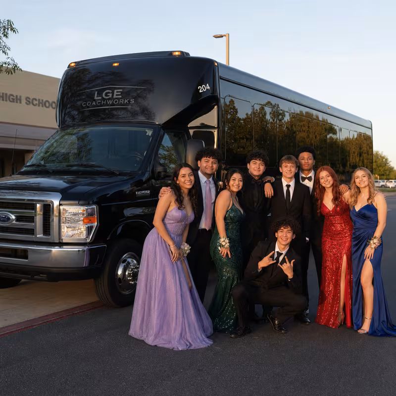 Group boarding a white charter bus for Prom & Homecoming Transportation transportation in Lincoln