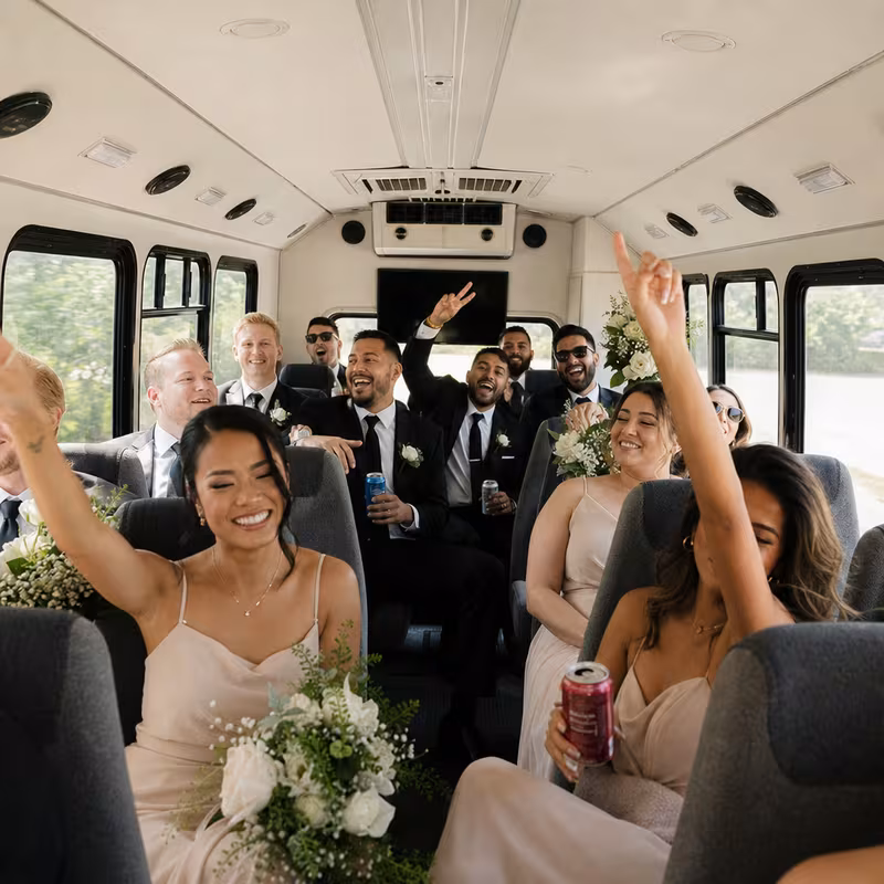 Group boarding a white charter bus for Wedding Transportation transportation in Lincoln